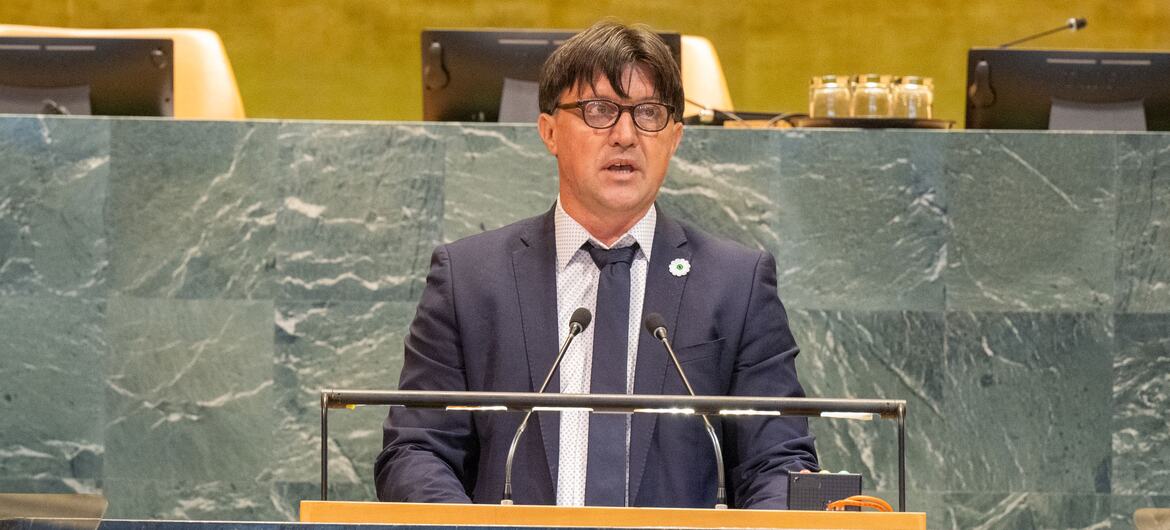 Man speaks at a podium with the United Nations logo during an event in New York.